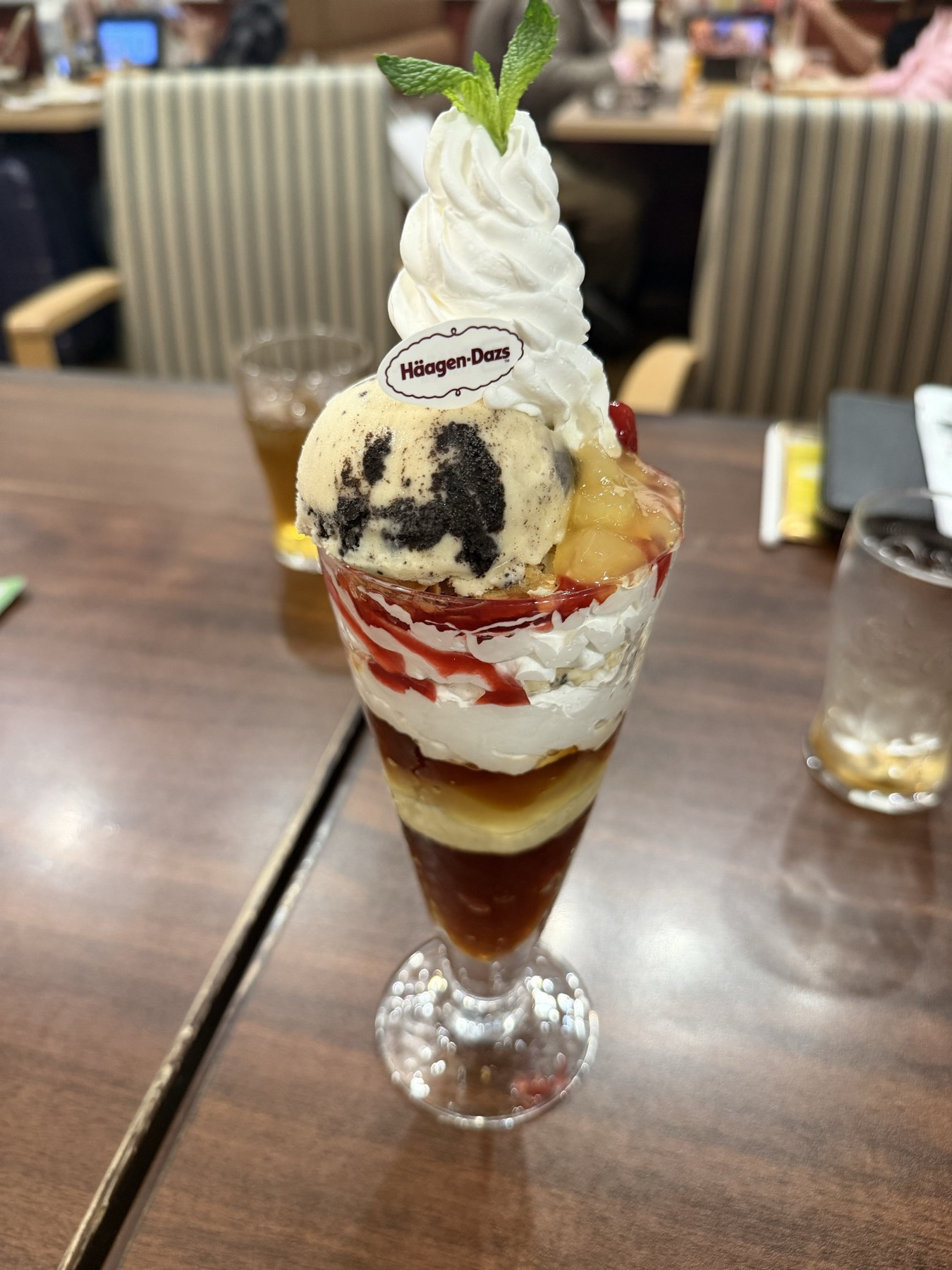 A tall Haagen-Dazs parfait with cream, fruit, and ice cream.